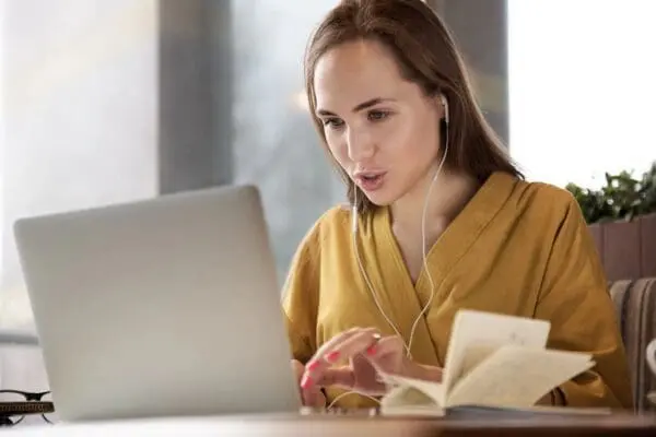 qtq80-C6wYja Woman using a laptop with earphones.